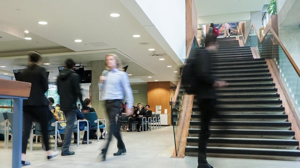 students walking in a busy room (students are preparing for job interviews). Students are blurred out to give an uneasy feeling