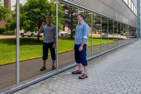 Professor Craig Kaplan outside the Davis Centre looking at his reflection