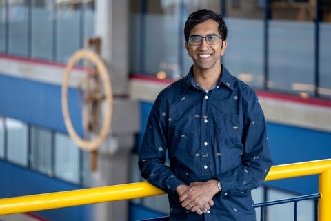 Professor Gautam Kamath in the Davis Centre by analogue clock