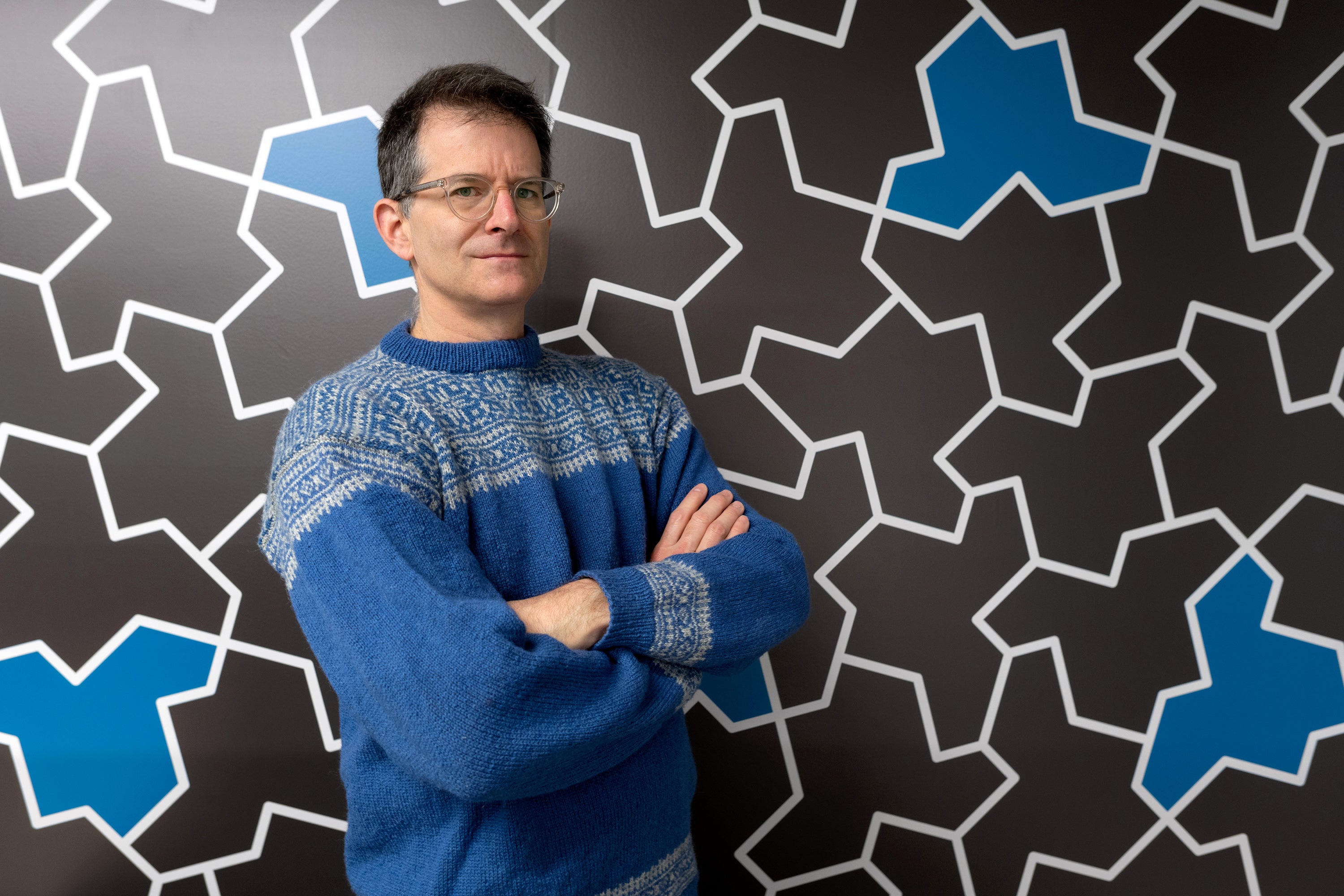 Professor Craig S. Kaplan in front of wall with aperiodic monotiles