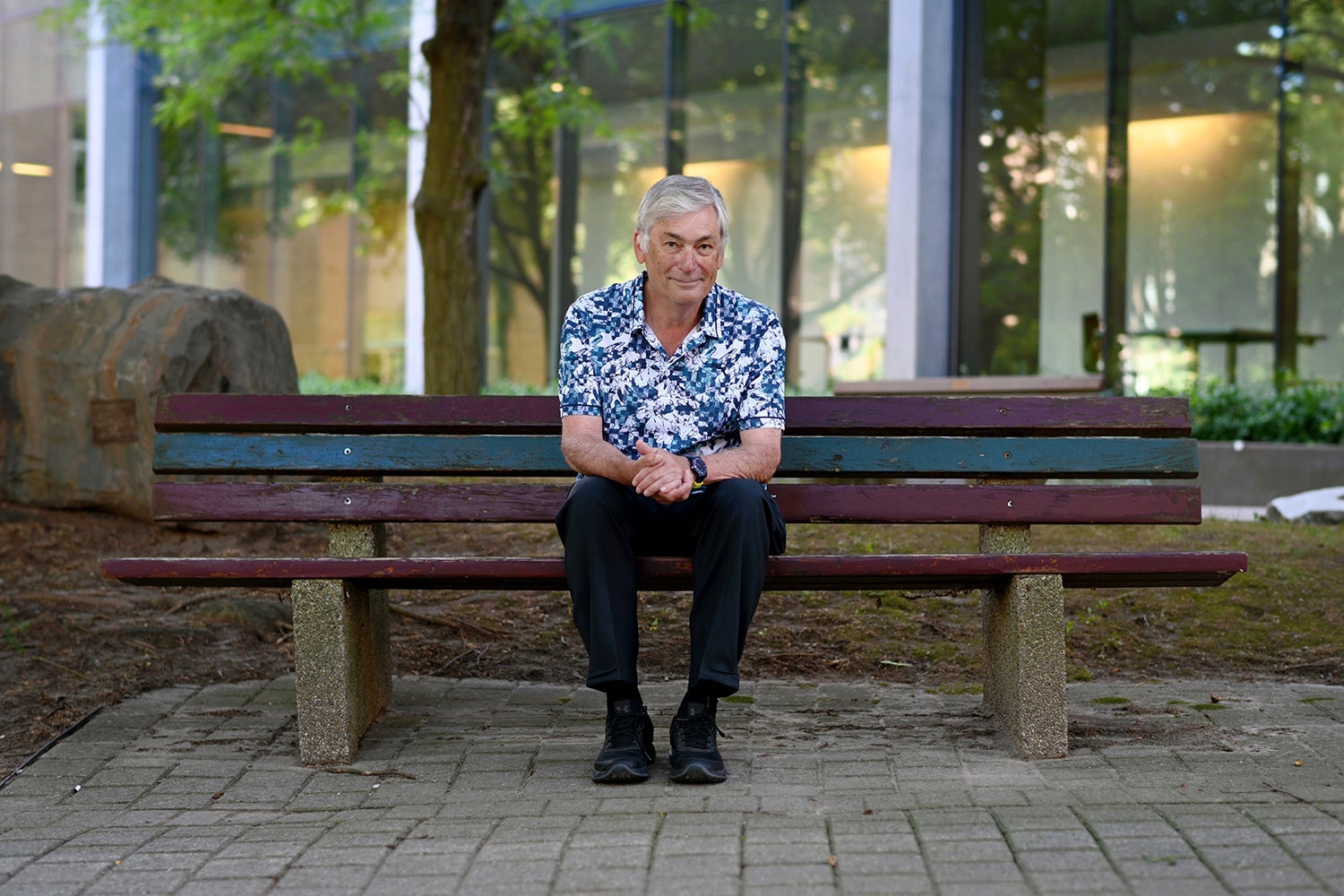 photo of Distinguished Professor Emeritus Ian Munro on bench in Waterloo's rock garden
