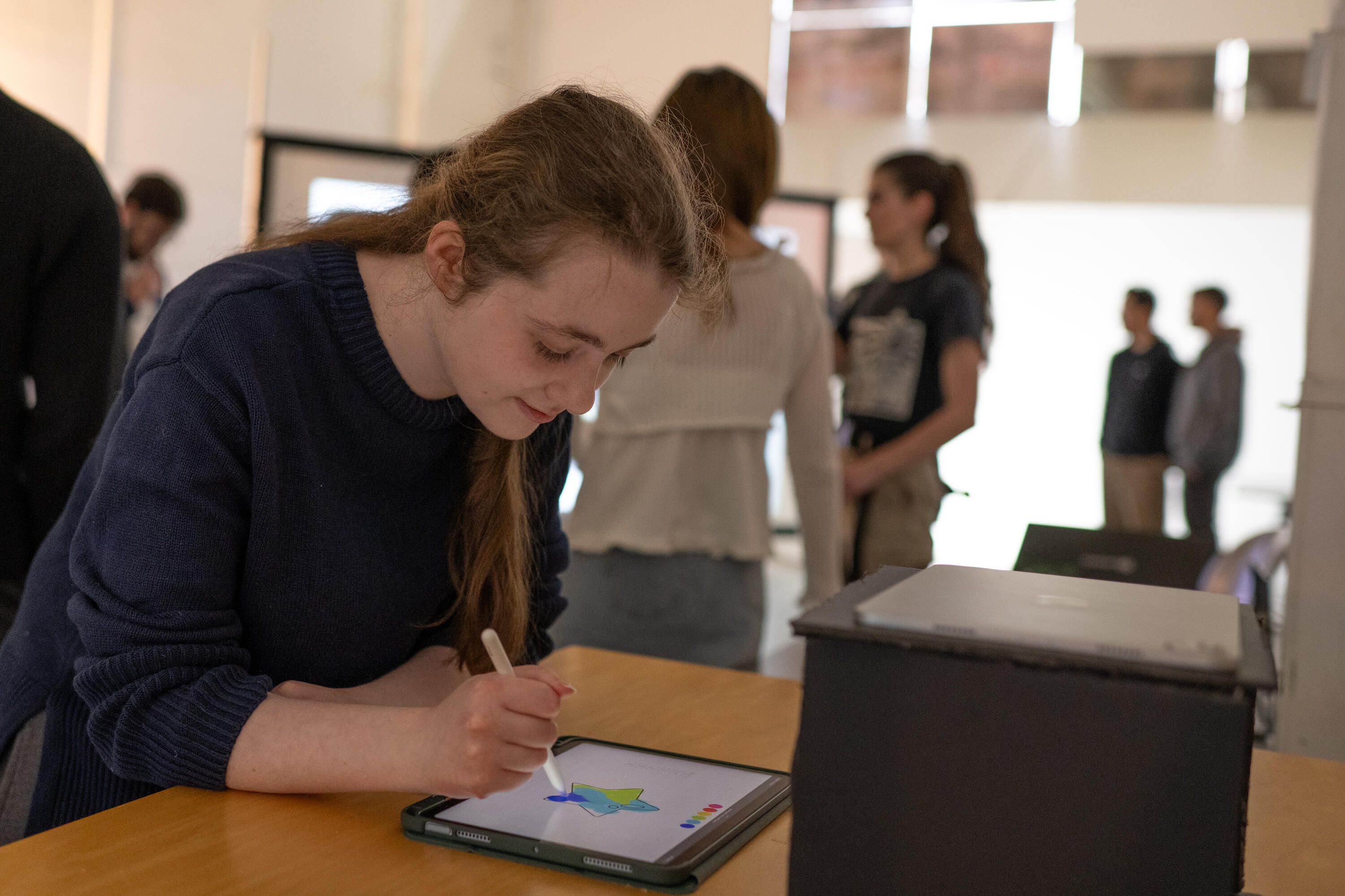 Photo of an attendee drawing on a star on an ipad.