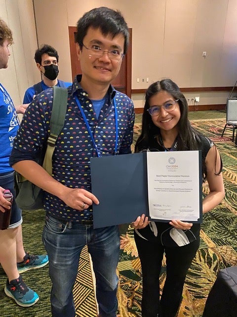photo of Allen and Nikhita holding their awards
