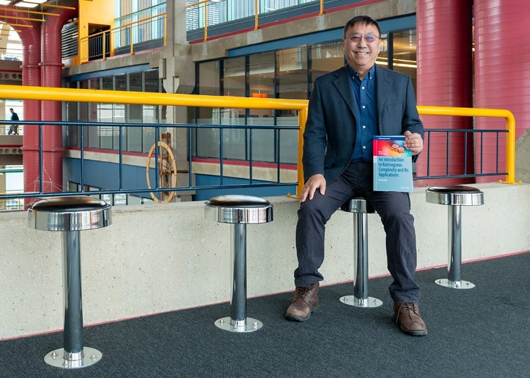 Professor Ming Li holding An Introduction to Kolmogorov Complexity and Its Applications